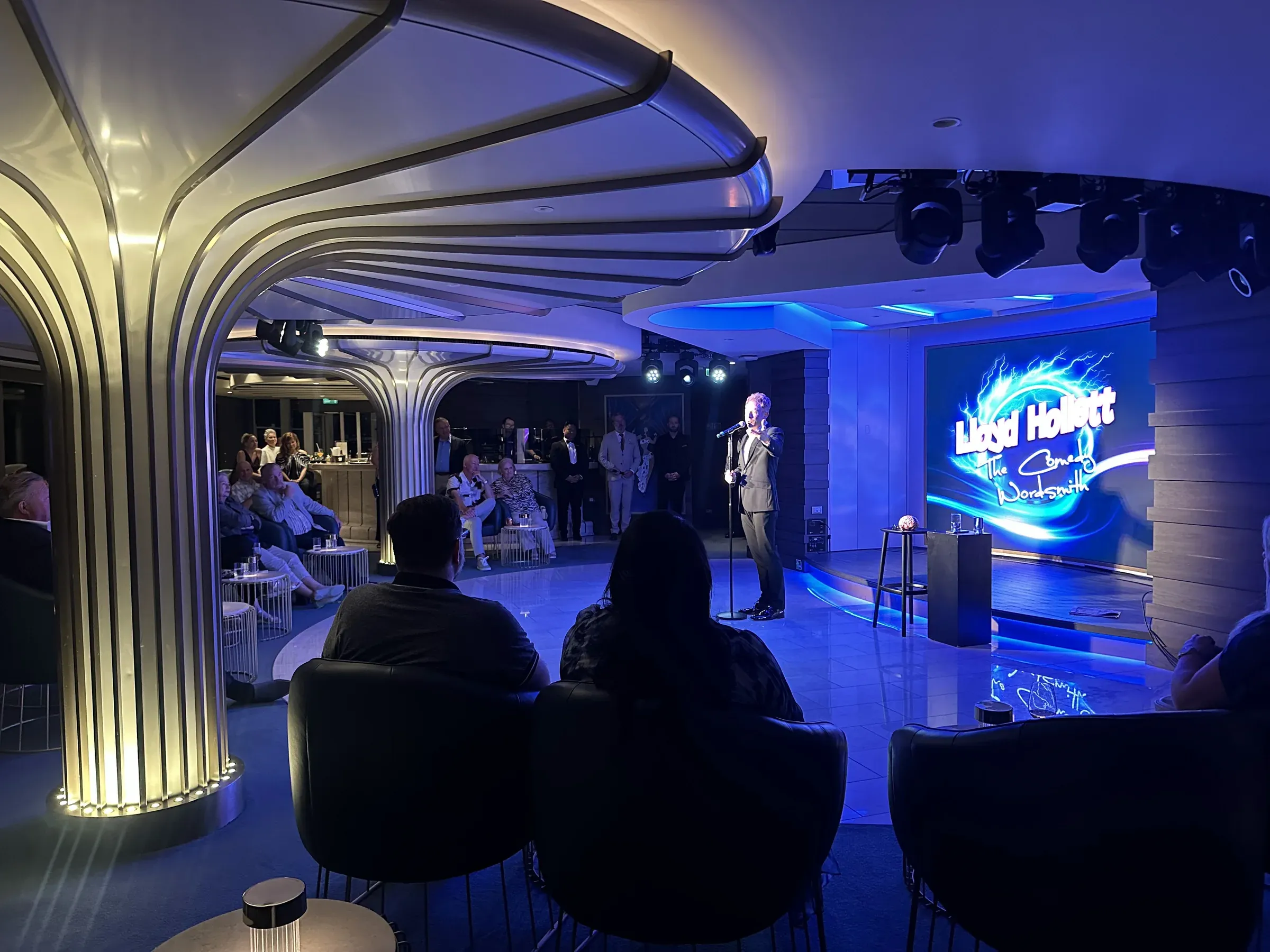 A bar aboard Explora I lit blue, a sculptural column at its center