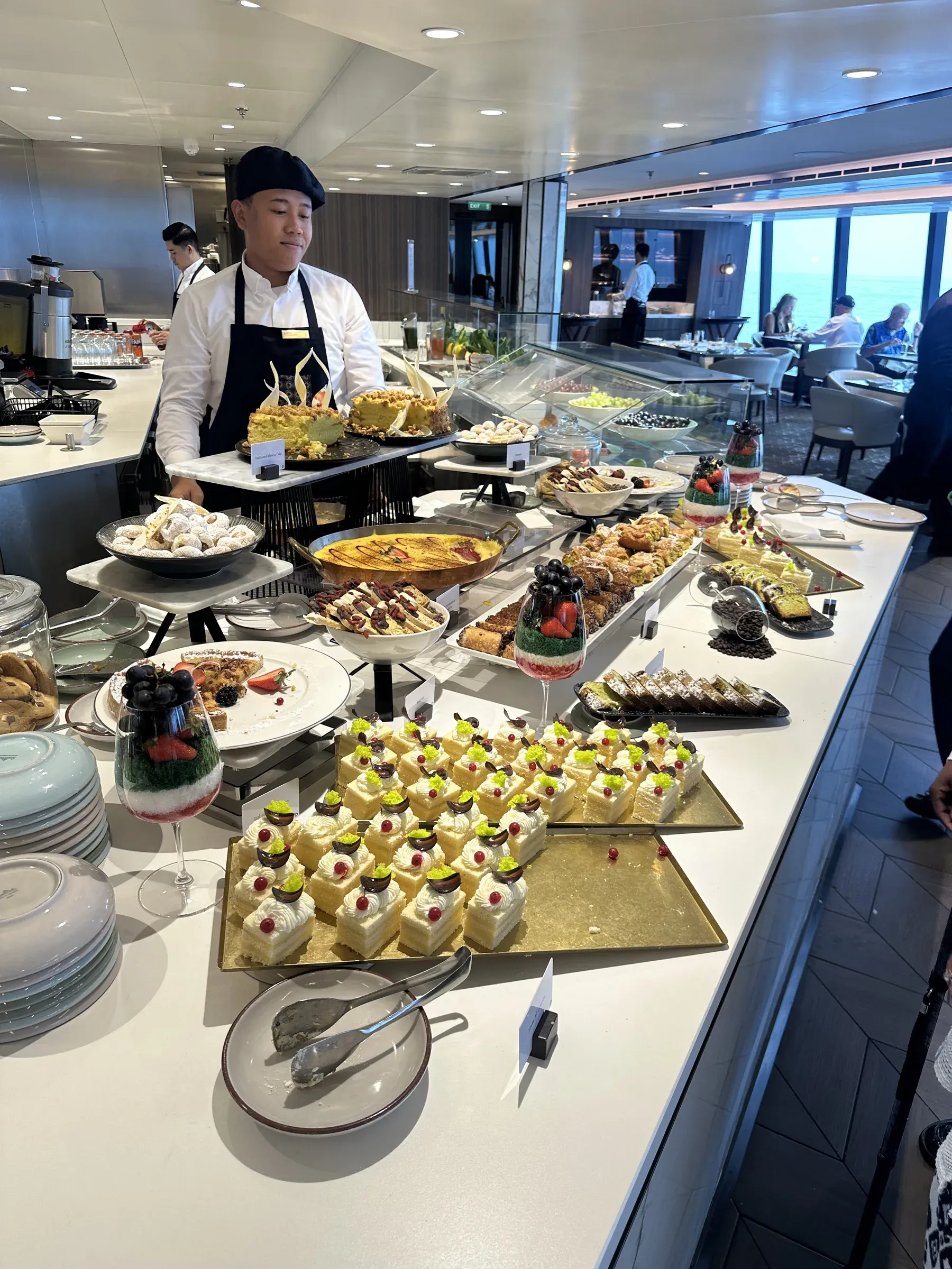 A chef plating at the breakfast marketplace aboard Explora I