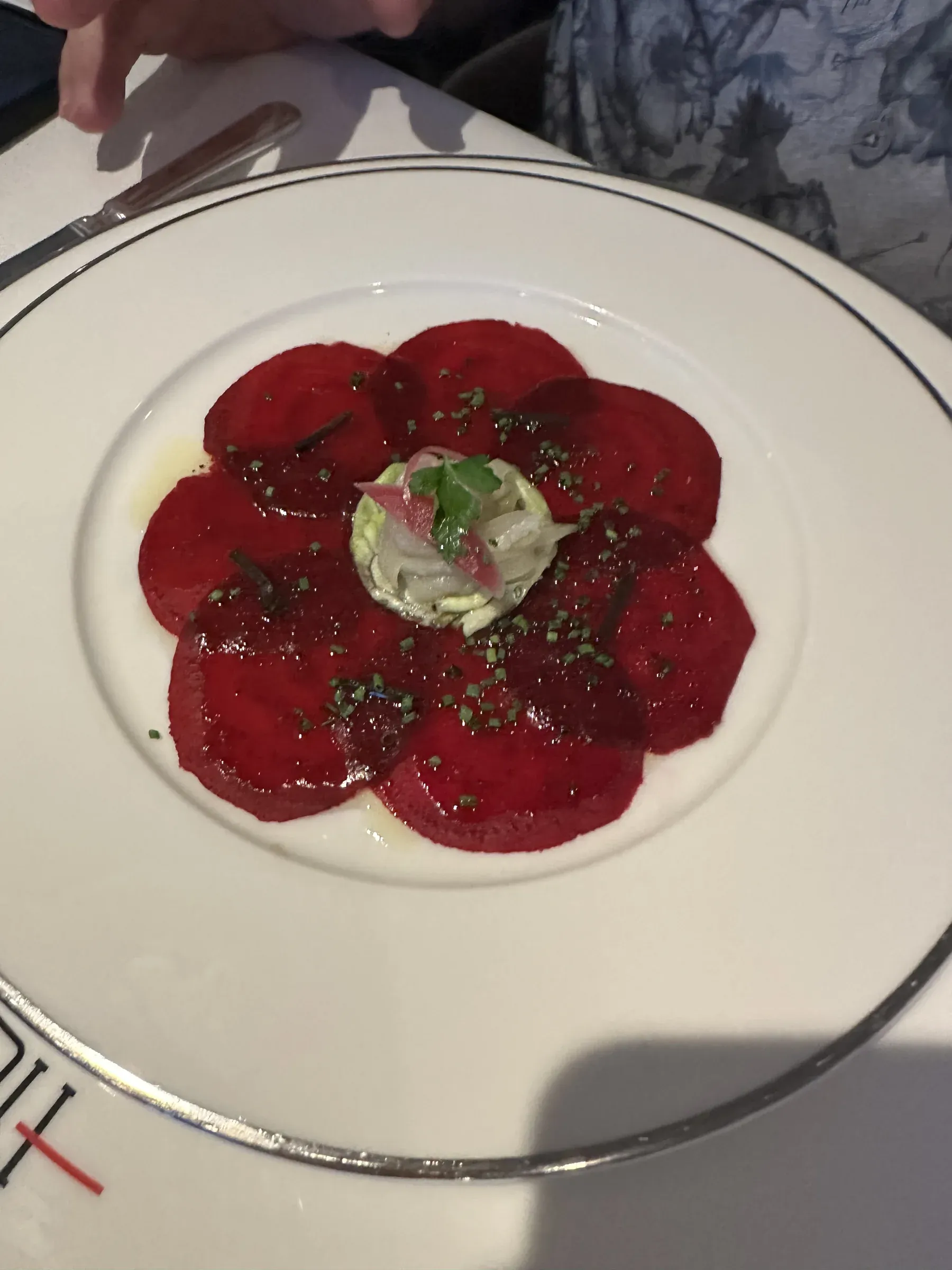 A beef carpaccio plated like a flower at dinner aboard Explora I