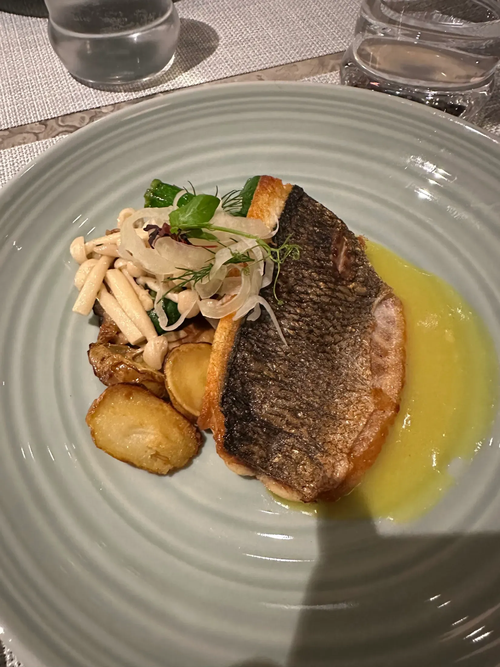 A crisp-skin sea bass with fennel and potatoes, plated at dinner on my Explora sailing