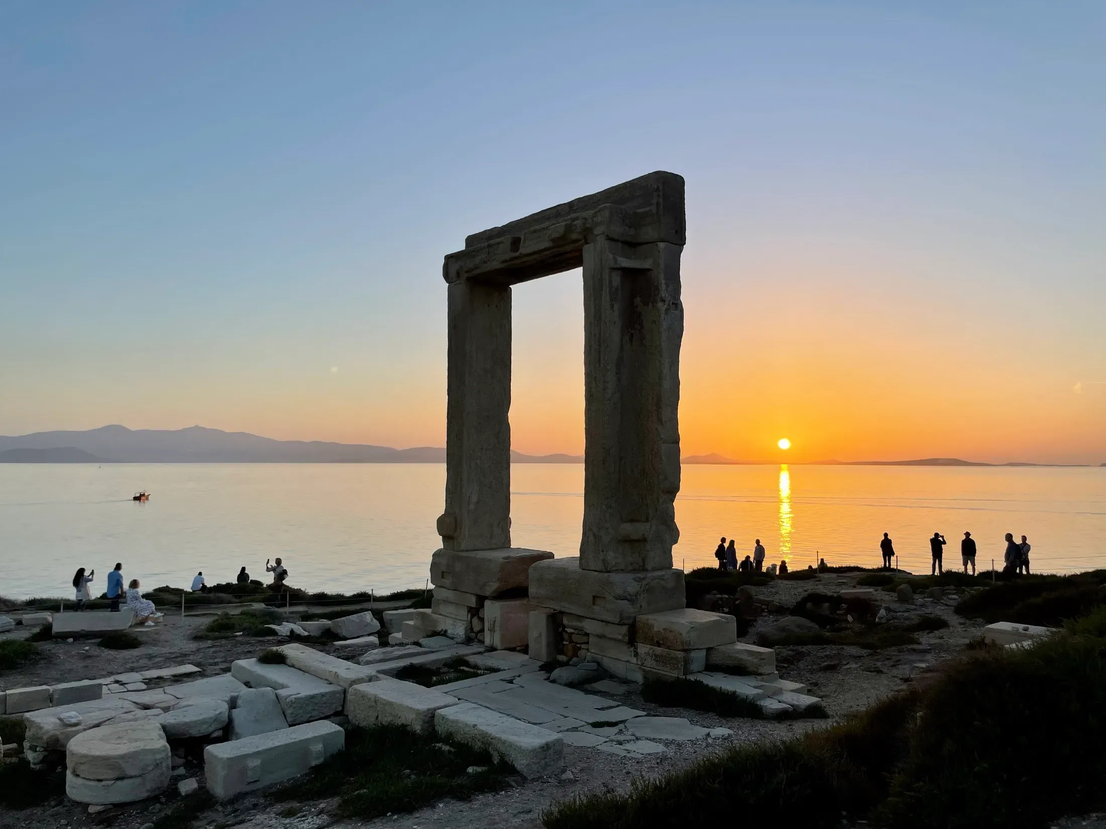 The Portara, a freestanding marble temple gateway on the Naxos headland, silhouetted at sunset