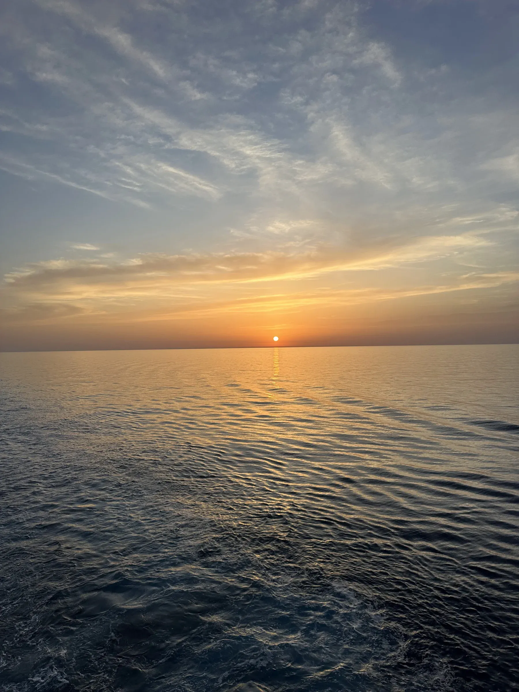 Sun low over the sea through breaking cloud, from Explora I