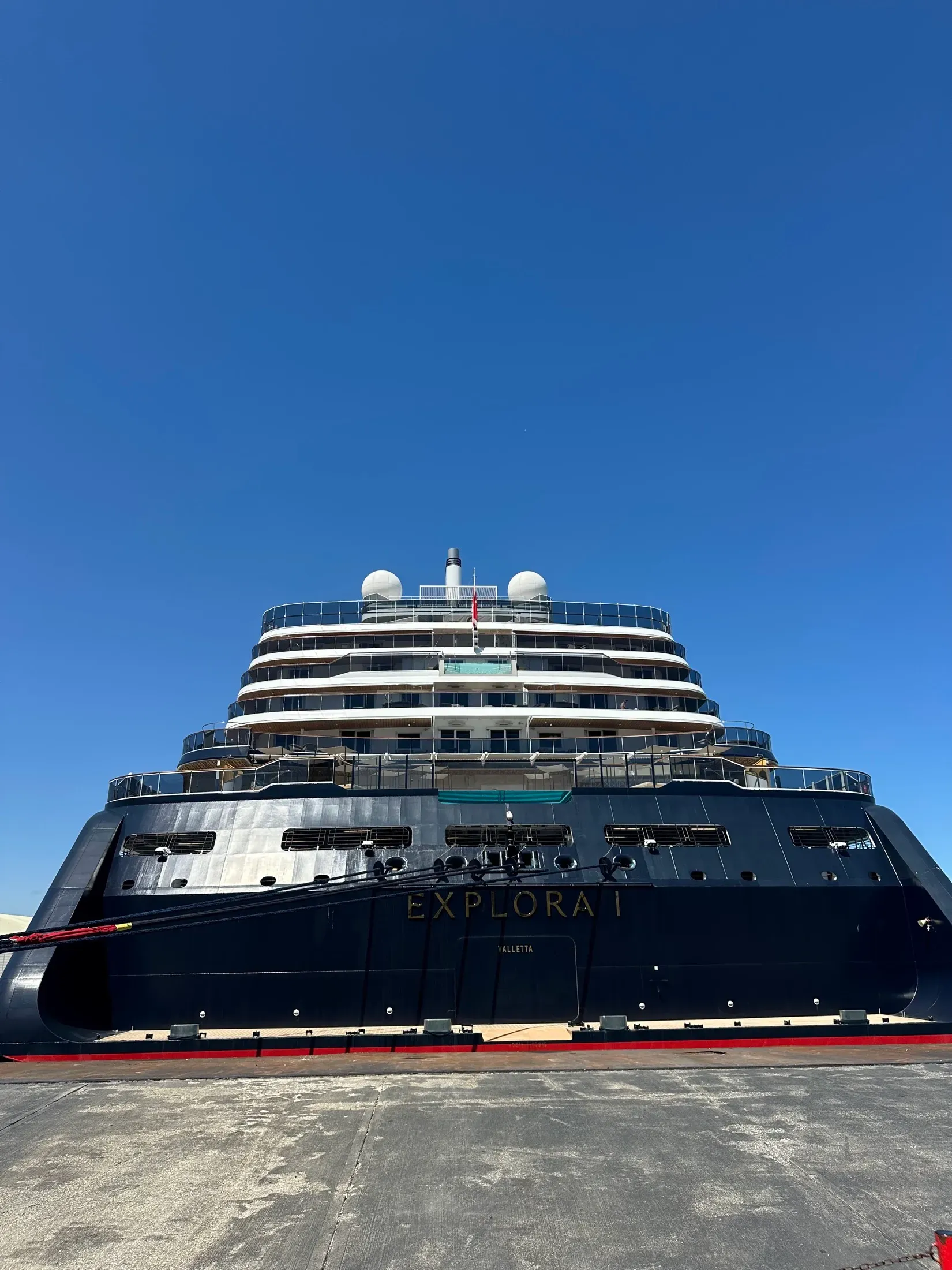 Explora I docked in port, the ship's name visible on the dark hull
