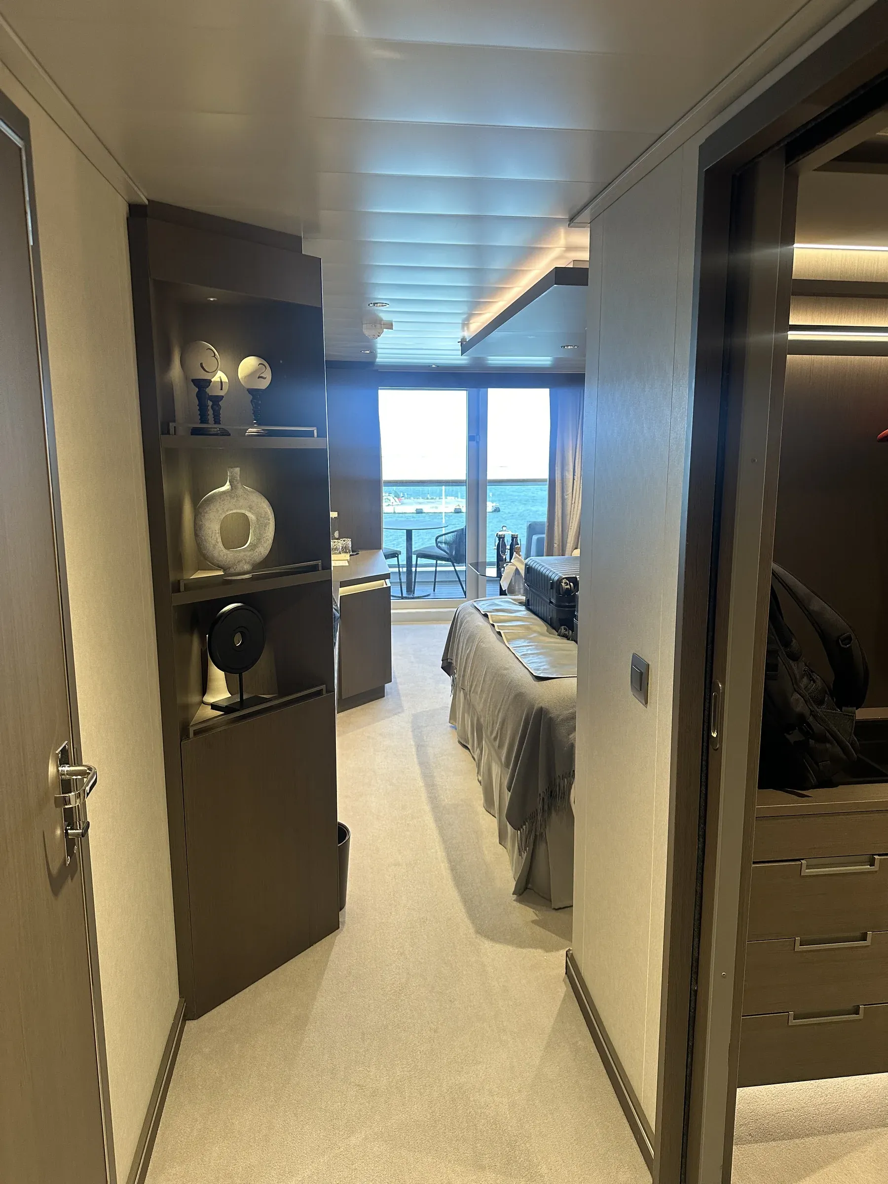 The entry of my suite aboard Explora I, with the minibar nook and wood cabinetry