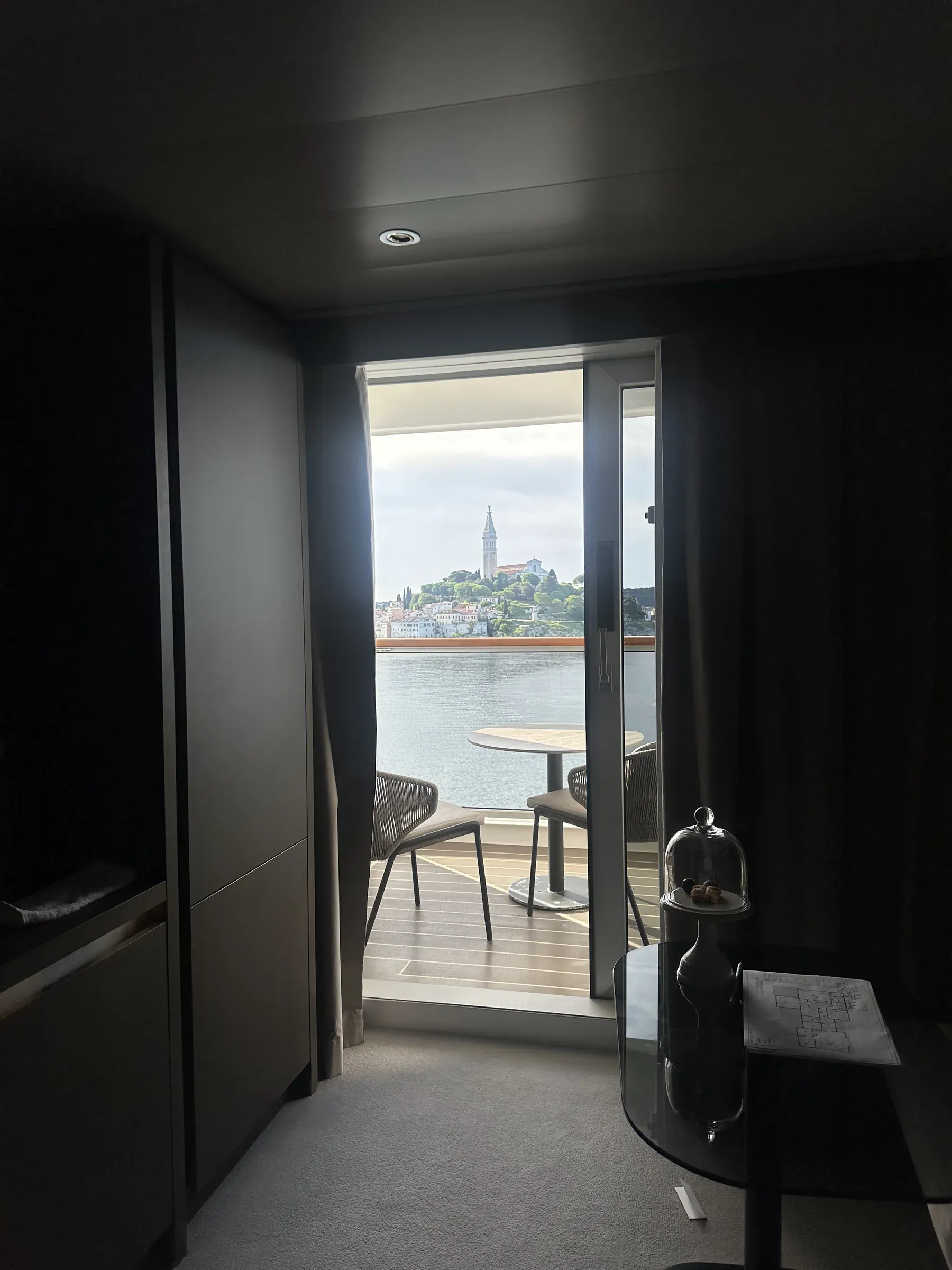 My suite's living area aboard Explora I in the evening, the terrace doors to the dark sea