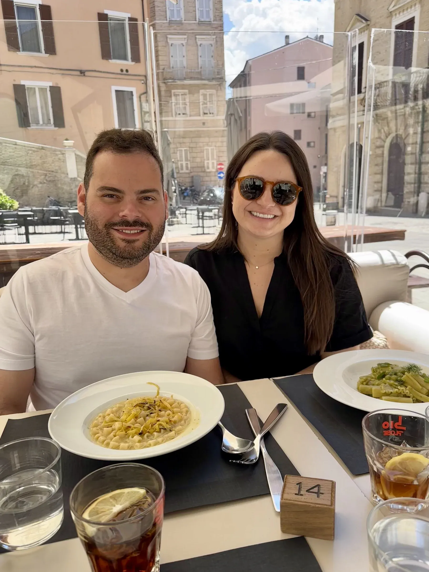 My wife and me at an outdoor table in Ancona, Italy, with plates of pasta on a shore day